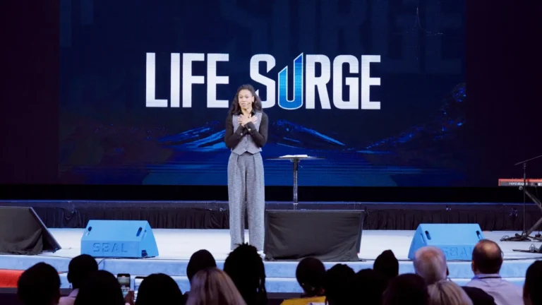Priscilla Shirer speaking on stage at Life Surge Washington, D.C. 2025 faith and business event, with the Life Surge logo displayed behind her.