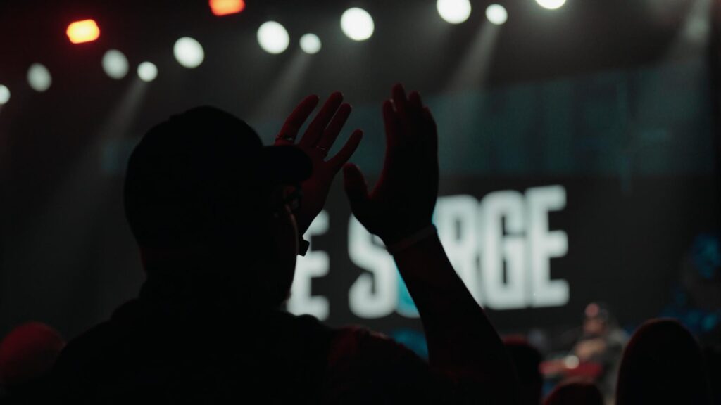 Attendee clapping at Life Surge Grand Rapids with the stage in the background