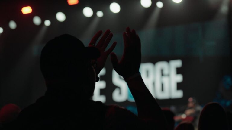 Attendee clapping at Life Surge Grand Rapids with the stage in the background