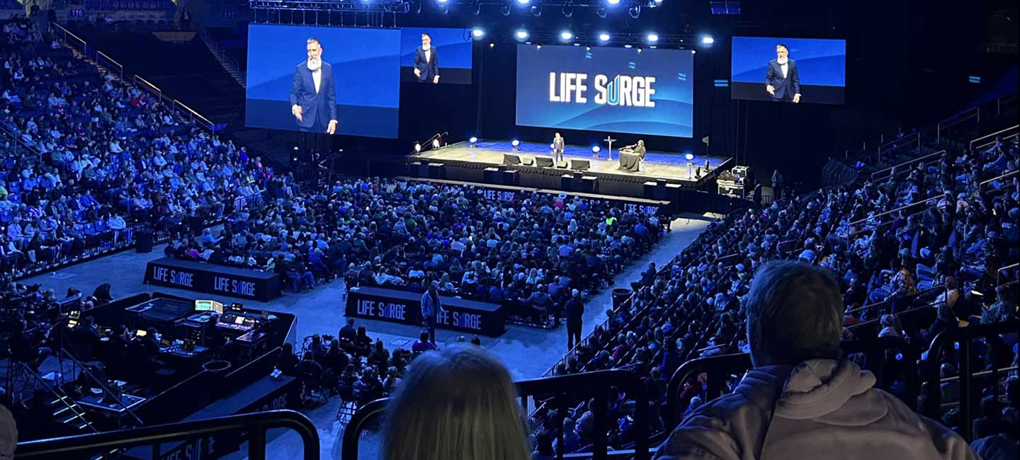 Speakers presenting on stage at a Life Surge event